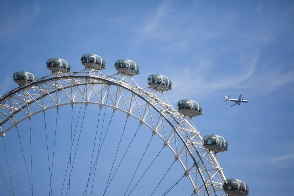 View of the London Eye with a plane flying above